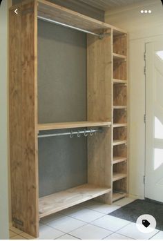 an empty closet is shown with shelves and shelving units on the floor, in front of a white door