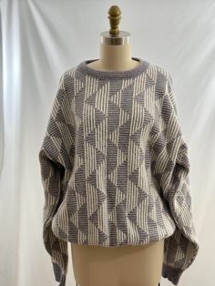 a mannequin head wearing a sweater on top of a white and gray background