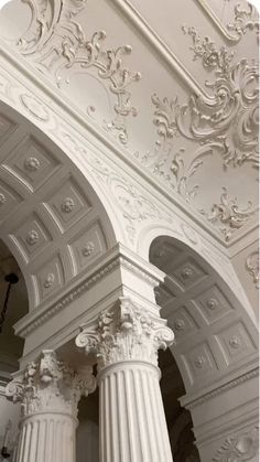 an ornate white building with columns and arches on the ceiling is seen in this image