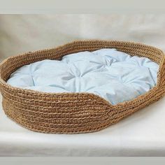 a basket that is sitting on top of a white surface with a blue blanket in it