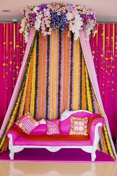 a pink couch sitting under a canopy covered in flowers