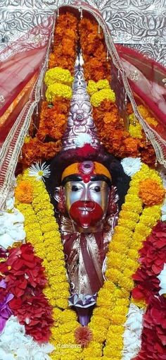 an idol is displayed with flowers around it