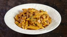 a white bowl filled with pasta covered in sauce