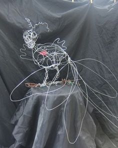 a wire sculpture sitting on top of a black sheet