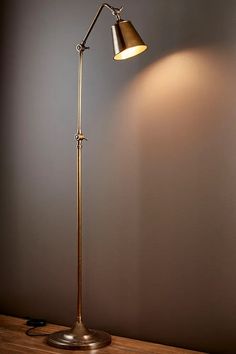 a lamp that is sitting on top of a wooden table in front of a gray wall