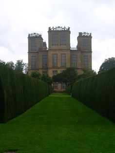 a very tall building with many windows on it's sides and green grass in the foreground