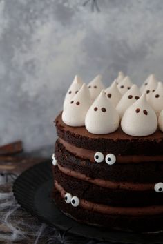 a chocolate cake topped with white frosting and eyes