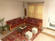 a living room with red couches and rugs