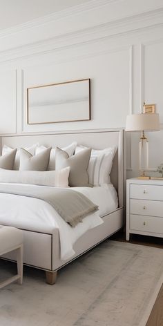 a large white bed sitting in a bedroom next to a window