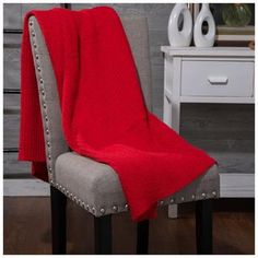 a red blanket sitting on top of a gray chair