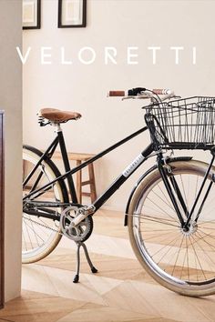 a black bicycle parked in front of a white wall with the words veloretti on it