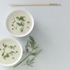 two white bowls filled with soup next to chopsticks on top of a table