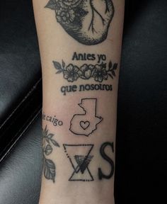 a tattoo on the arm of a person that has various symbols and words around it