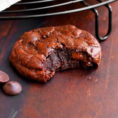 a chocolate cookie with one bite taken out of it and another half eaten on the table