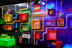 a colorful display with legos on the wall and shelves in different colors, including neon lights