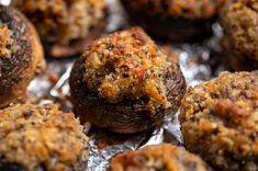 baked meatballs sitting on top of tin foil covered in sauce and seasoning sprinkles