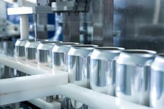 several rolls of aluminum foil are lined up on a conveyor belt in a factory