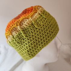 a white mannequin head wearing a multicolored crocheted knit hat