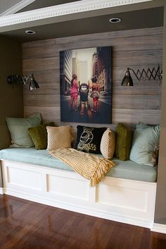 a living room filled with lots of furniture next to a wall covered in pictures and paintings