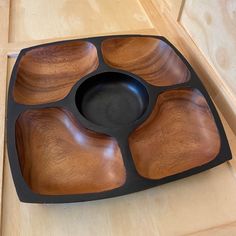 a wooden tray with four compartments on it