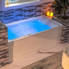 a bathroom with a large jacuzzi tub next to a window and candles on the wall