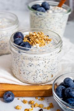 three glass jars filled with oatmeal and blueberries on top of a table