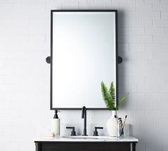 a bathroom vanity with a mirror and two faucets on the counter top next to it