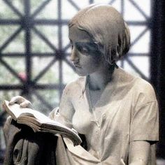 a statue of a woman reading a book