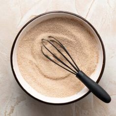 a whisk in a bowl with powdered sugar