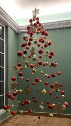 a christmas tree made out of red and white ornaments hanging from it's ceiling