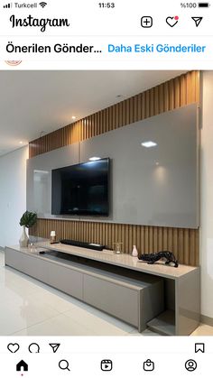 a flat screen tv mounted to the side of a wall next to a white counter