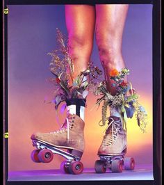 two skateboarders with flowers on their feet and one is wearing laces while the other wears boots