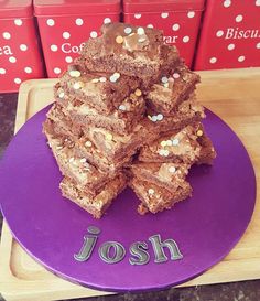 a purple plate topped with brownies covered in sprinkles