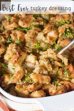 a casserole dish filled with stuffing and garnished with fresh parsley