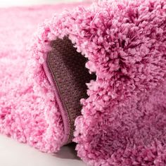 a close up of a pink rug on a white surface with a hole in the middle