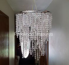 a chandelier hanging from the ceiling in a hallway next to a wooden door