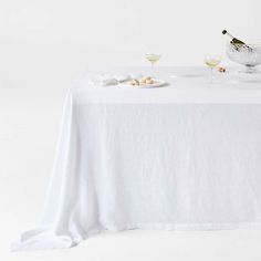 a table topped with two glasses of wine and an empty plate