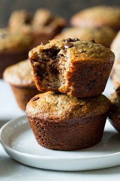 three muffins stacked on top of each other on a plate next to more muffins