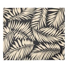 a black and white rug with palm leaves on it