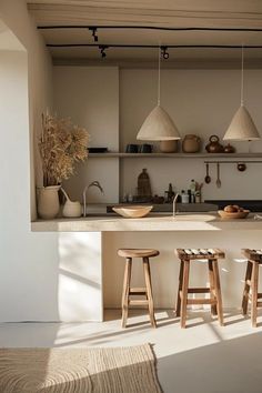 three stools sit in front of the kitchen counter