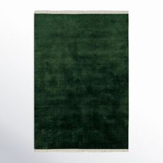 a dark green rug with white border