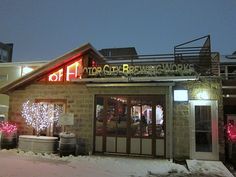 a building that has some lights on the front and side of it in the snow