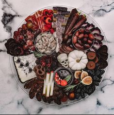 a platter filled with lots of different types of food on top of a marble table