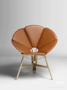 an orange leather chair sitting on top of a wooden table next to a white wall