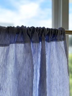 a blue and white striped curtain hanging in front of a window