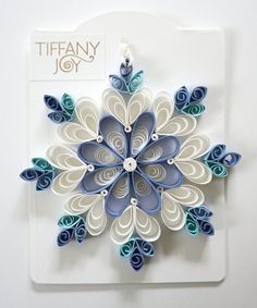 an origami snowflake is displayed on a white plate with the word tiffany joy above it