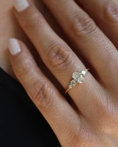 a woman's hand with a three stone ring on her left and right hand