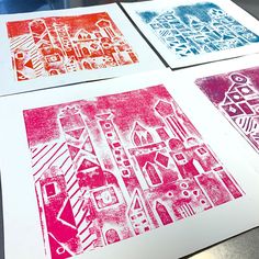 three different colored paper prints on a table