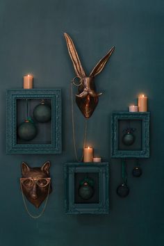 the wall is decorated with candles and decorative animal head heads, which are hung on blue frames