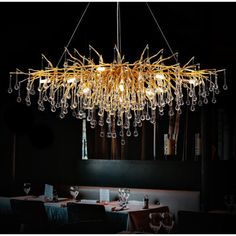 a chandelier hanging from the ceiling in a dining room with table and chairs